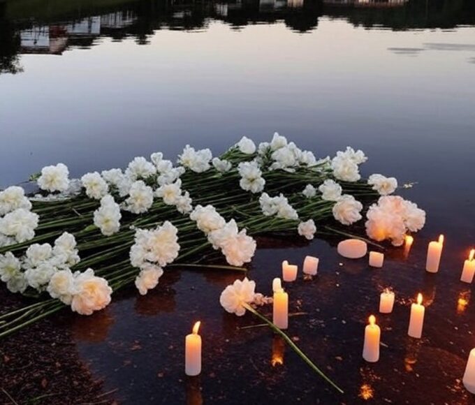 Memorial simbólico com flores e velas à beira do Lago dos Tigres em Britânia, Goiás, homenageando vítima de assassinato.